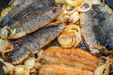 frischer brathering mit zwiebeln in der pfanne