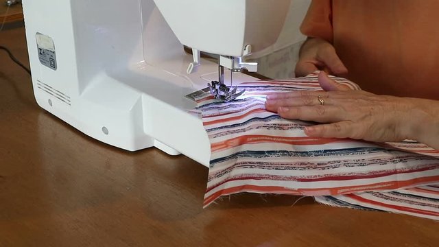 Costurando roupas feitas artesanalmente em seu ateli&ecirc;