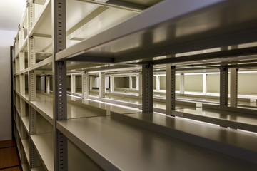 Empty metallic bookshelves with illuminated background