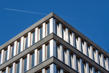 Facade office building. Business building. Blue Sky. Airplane in the background. 