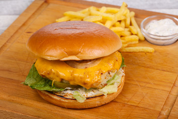 Homemade burger with fish, cheese and salad leaves