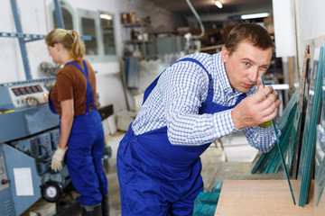 Workman working with glass in workshop