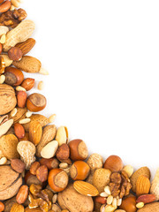 Background of mixed nuts - hazelnuts, almonds, walnuts, pistachios, peanuts, pine nuts peeled and not peeled - vertical with copy space. Isolated one edge. Top view or flat lay