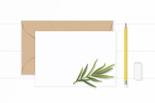 Flat lay top view elegant white composition letter kraft paper envelope yellow pencil eraser and tarragon leaf on wooden background
