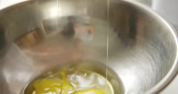 Slow motion crop shot of person opening the egg with the knife