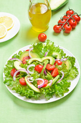 Salad with letuce leaves, avocado, cherry tomatoes and onion