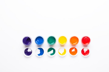 Six jars of paint on a white background Isolated Multicolored gouache Top view