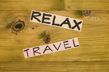 Image of words relax and travel on wooden table.Toned photo.