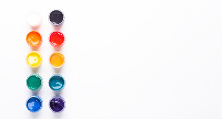 Containers with paints on a white background Multicolored gouache Isolated Top view Banner Horizontal