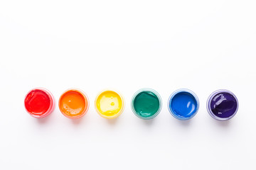 Six jars of paint on a white background Isolated Multicolored gouache Top view