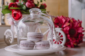 Pink french macarons under the glass on the wooden boards, soft focus background. Sweet desert In the local cafe.