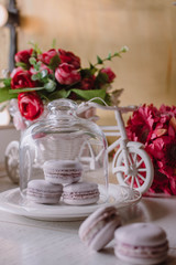 Pink french macarons under the glass on the wooden boards, soft focus background. Sweet desert In the local cafe.