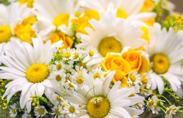 Bright bouquet of big and small chamomiles and yellow roses