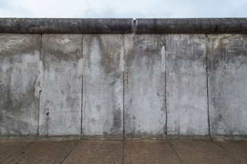 Front view of a section of the original Berlin Wall at the Berlin Wall Memorial (Berliner Mauer) in Berlin, Germany, on a cloudy day.