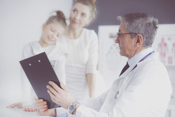Obraz premium Little girl with her mother at a doctor on consultation