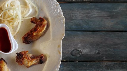 Chicken Kebab with onions on pita close up. Rotates on a wooden background. Top view with the copy space for your text.