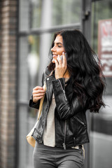 Fototapeta premium Latin woman with smartphone speak with friends