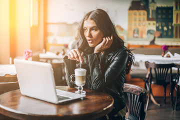 Young pretty spanish woman in cafe in city centre with tablet laptop