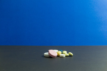 Capsule pills medical, white and pink, on a blue background.