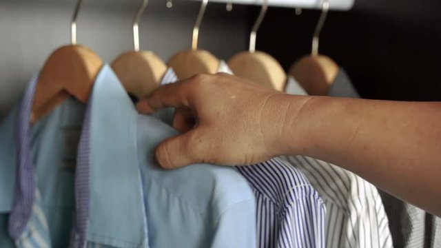 closed up, A businessman chooses shirt in your wardrobe before you go to work or before a night out. 