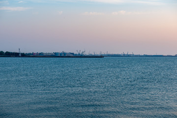Obraz premium calm sea beach in summer with large rocks and wooden poles from old breakewater in the sea