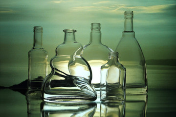 Empty glass bottles on a cloudy sky background.