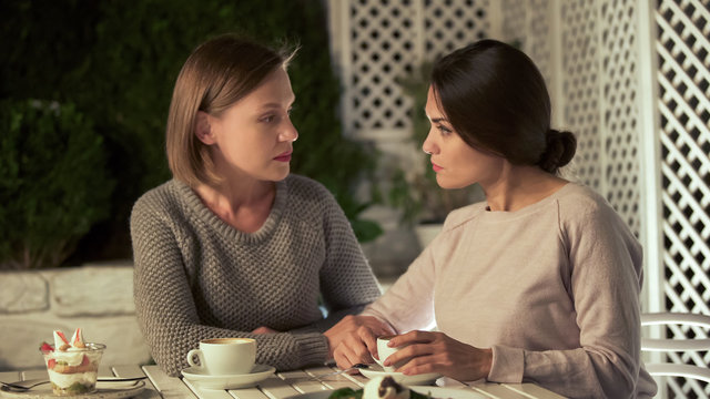 Sisters talking about life, sitting on terrace together, problem discussion