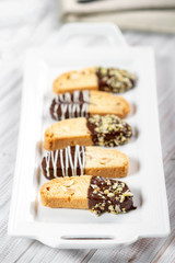 Cantuccini biscuits with chocolate and pistachios. Italian biscotti on white plate