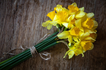 Bouquet of yellow narcissus on wooden table