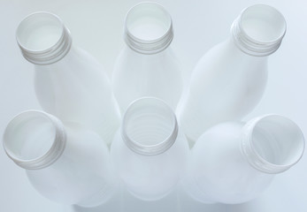 Empty white plastic milk bottles on White background