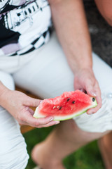 Pritty woman is holding a slices of watermelon on a dark background. slow motion