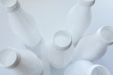 Empty white plastic milk bottles on White background