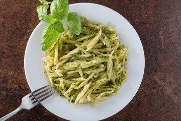 Traditional trofie pasta with pesto sauce on white plate