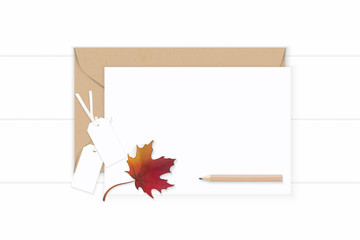 Flat lay top view elegant white composition letter kraft paper envelope pencil autumn maple leaf and tag on wooden background