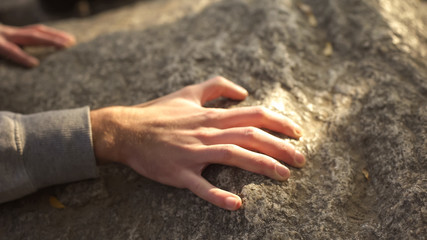 Male climbing rock, reaching top, active spending of leisure time, mountain