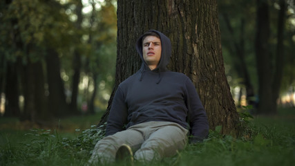 Sick man feeling dizziness and faintness under tree, needs help, suffer diabetes