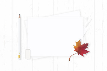 Flat lay top view elegant white composition pencil eraser tag and autumn maple leaf on wooden background