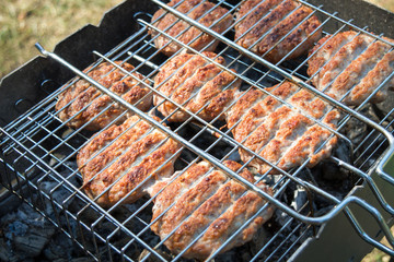 Beef or pork meat barbecue burgers for hamburger prepared grilled on bbq  grill, high angle view, close up