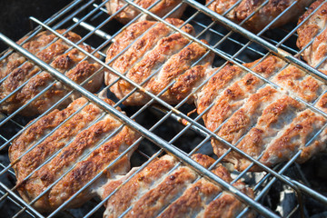 Beef or pork meat barbecue burgers for hamburger prepared grilled on bbq  grill, high angle view, close up