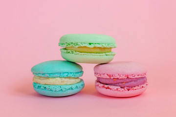 Sweet almond colorful unicorn blue green pink macaron or macaroon dessert cake isolated on trendy pink pastel background. French sweet cookie. Minimal food bakery concept. Copy space