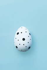 Easter holiday creative background with one white Easter egg on blue background. Flat lay, top view. Easter concept