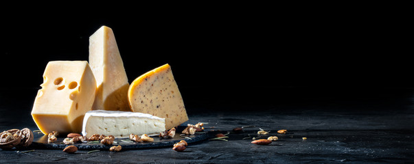 Fototapeta Different kinds of cheese with nuts on dark background, copy space obraz