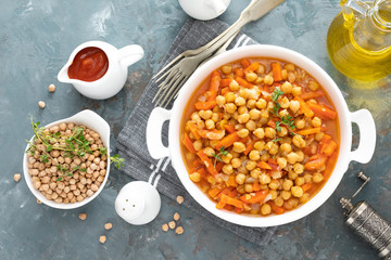 Chana Masala, spicy chickpea curry with carrot and onion in tomato sauce. Vegetarian dish for lunch. Indian cuisine