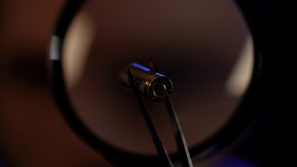 Gun bullet under magnifying glass, forensic science, ballistics experiment