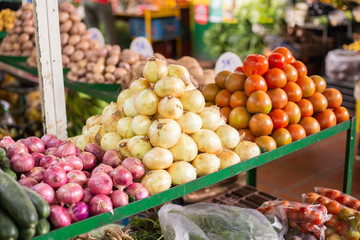 pile of tomatoes and red and white onion in the market
