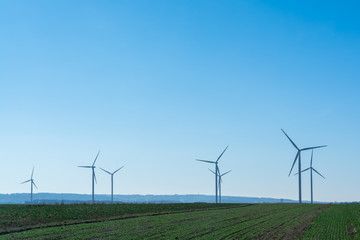 Field with windmills for electric power. Clean energy produced by the wind. Extraction of energy from the air