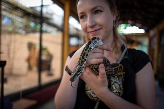 Caucasian girl holds snake in Langkawi Wildlife Park