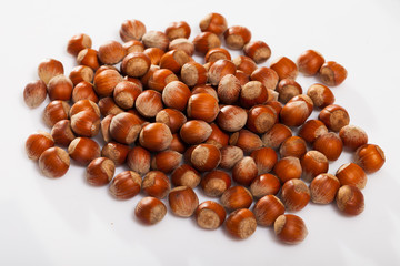 Obraz premium Unpeeled hazelnut on white surface closeup