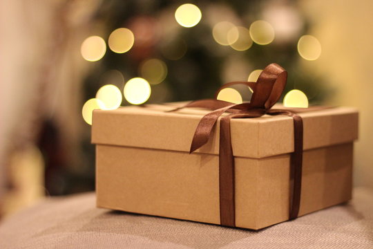 close-up open and closed gift box with brown ribbon
