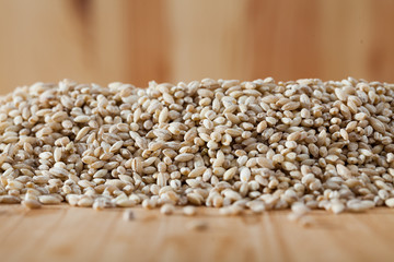 Obraz premium Pearl barley on a wooden surface, macro